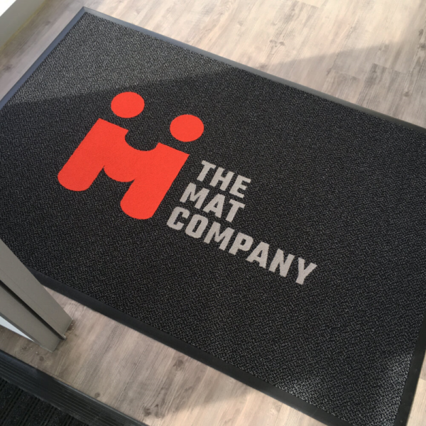 4' x 6' inlaid logo mat featuring Equinox matting with heavy-duty vinyl edge and a 7 sqft. logo made of Candy Apple (red) and Moon Beam (grey) commercial carpet